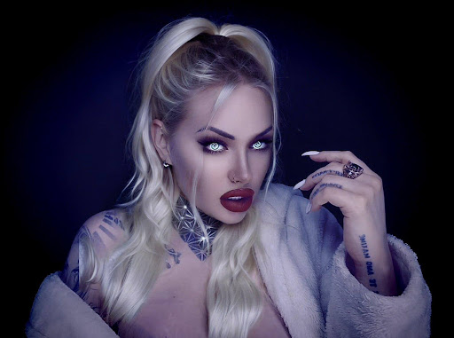 Mistress Goldy AKA The GOLDY rush with dark red lipstick on fluffy lips and eyeballs are torching blue light in the dark of the room and nude body with slightly covered fur coat