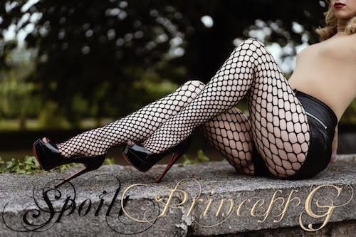 Princess Grace posing outdoor by sitting on a stone laid fence in black mesh stockings and black high-heels and a body color upper tight cloth