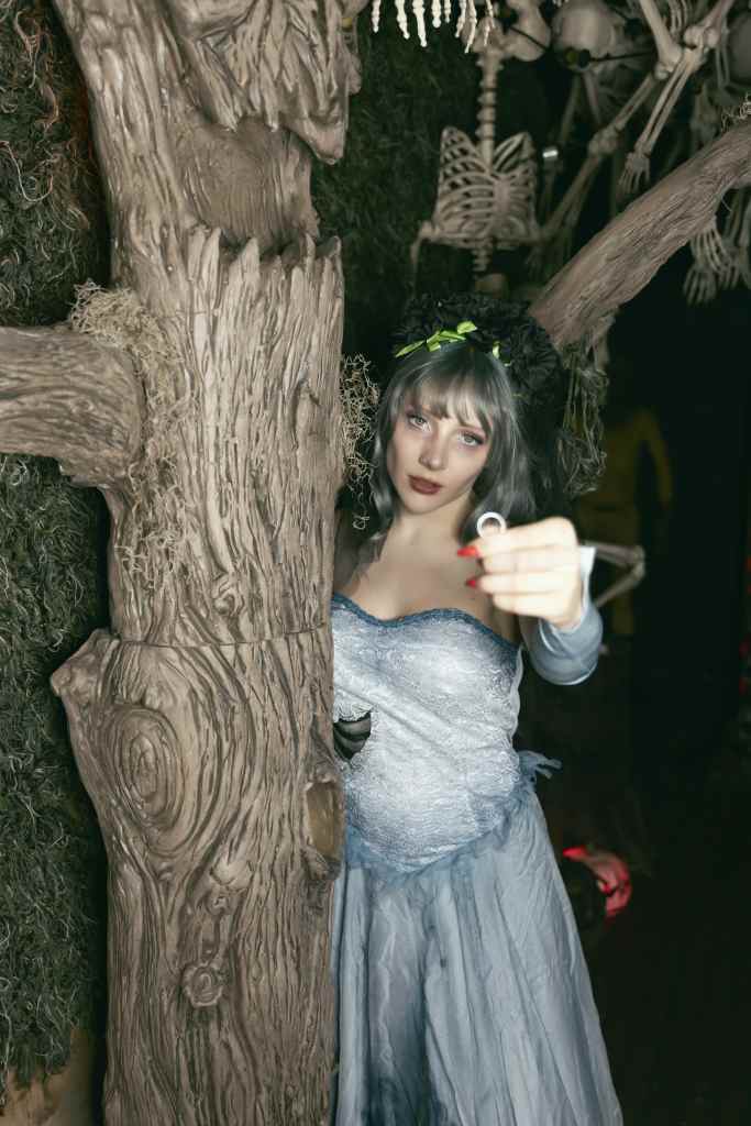 Goddess Kristie aka Kristie Bish in a corpse bride cosplay costume, holding a ring in her hand