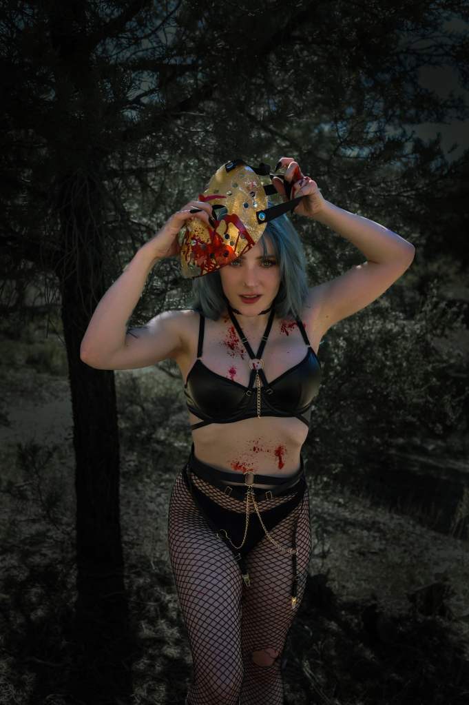 Goddess Kristie aka Kristie Bish, in black mesh pantyhose and a black bra, is putting Jason's mask on her
