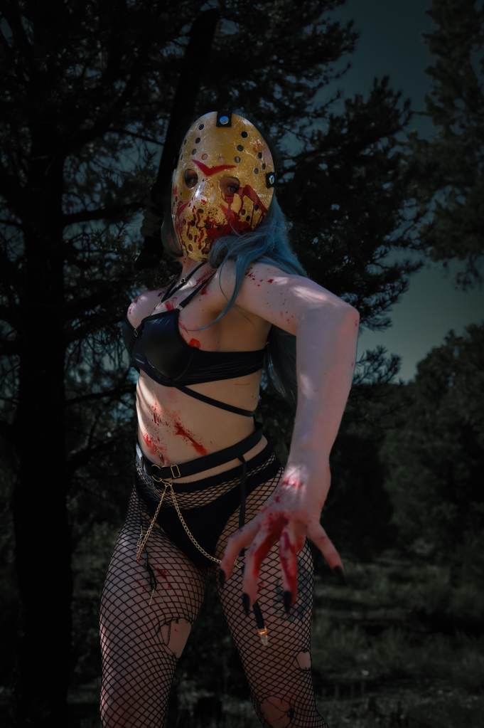 Goddess Kristie aka Kristie Bish, posing in Jason's mask, torn mesh pantyhose and black bra
